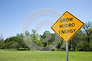 `GROW HYDRO ENERGY` ROAD SIGN AGAINST GREEN LANDSCAPE AND BLUE SKY