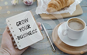 Grow your business words on office table with computer, coffee, notepad, smartphone