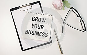 Grow your business words on office table with computer, coffee, notepad, smartphone