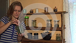 Grower woman smell mint herbs in jar and smile. Static shot. 4K