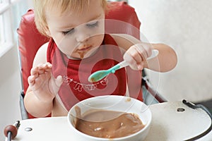 Growing boy needs his food. A young baby boy eating to his hearts content in his high chair.