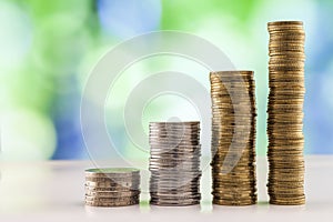 Growing coins stacks with green and blue sparkling bokeh background. Financial growth, saving money, business finance wealth and