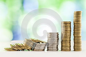 Growing coins stacks with green and blue sparkling bokeh background. Financial growth, saving money, business finance wealth and