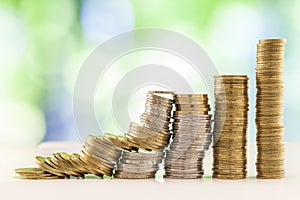 Growing coins stacks with green and blue sparkling bokeh background. Financial growth, saving money, business finance wealth and