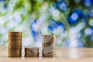 Growing coins stacks with green and blue sparkling bokeh background. Financial growth, saving money, business finance wealth and