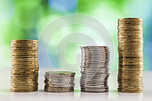 Growing coins stacks with green and blue sparkling bokeh background. Financial growth, saving money, business finance wealth and