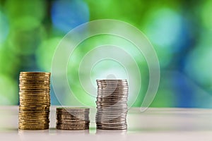 Growing coins stacks with green and blue sparkling bokeh background. Financial growth, saving money, business finance wealth and