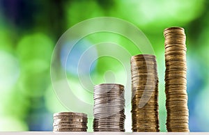 Growing coins stacks with green and blue sparkling bokeh background. Financial growth, saving money, business finance wealth and