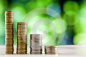 Growing coins stacks with green and blue sparkling bokeh background. Financial growth, saving money, business finance wealth and