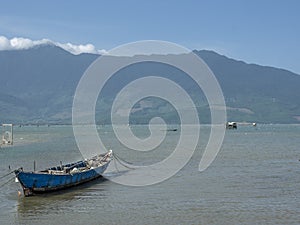 wooden boat in the water with moutains in background photo