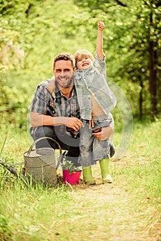 Growing plants. Take care of plants. Boy and father in nature with watering can. Spring garden. Dad teaching little son