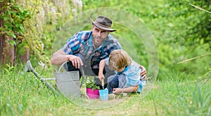 Growing plants. Take care of plants. Boy and father in nature with watering can. Gardening tools. Planting flowers. Dad