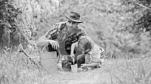 Growing plants. Take care of plants. Boy and father in nature with watering can. Gardening tools. Planting flowers. Dad