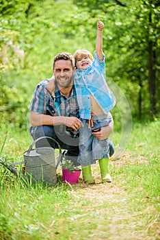 Growing plants. Take care of plants. Boy and father in nature with watering can. Spring garden. Dad teaching little son