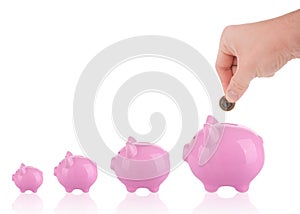 Growing savings - putting coin into piggy bank