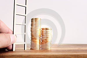 growing stack of coins on wooden table. financial success and managament concept