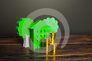 Growing stacks of coins and a green house. Economy and efficiency of green technology in housing. Investment grants and funding.