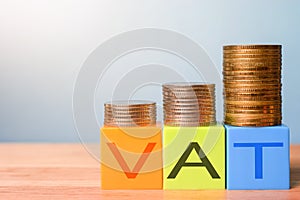 Growing taxes - colour blocks with VAT and money stacks