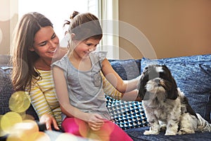 Growing up in a home of animal lovers. an adorable little girl, her mother and their dog spending time together at home.