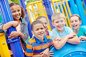 Growing up together. A multi-ethnic group of happy children playing on a jungle gym in a play park.