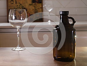 Growler bottle for craft beer and empty glass on a counter