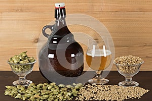 Growler and goblet of beer, with hops and malts photo