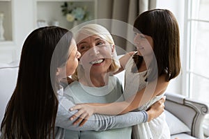 Grown daughter and little granddaughter hugging mature woman, congratulating