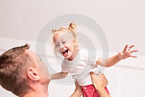A grown man carries his young daughter in his arms on father`s Day