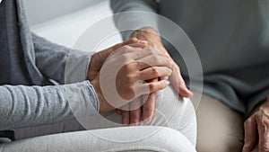 Grownup daughter holding mothers hand showing support closeup image