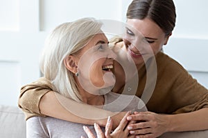 Grownup daughter hugging senior mom showing love and care