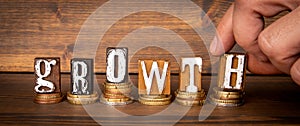 Growth business concept. Alphabet blocks and money on wood texture background