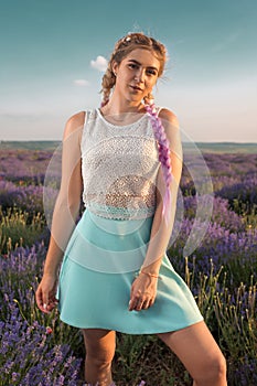 Growth portrait of a beautiful and sexy girl with long braids in a lavender field