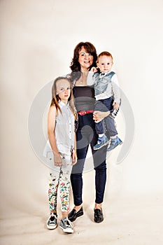 Growth portrait of happy mother with two children isolated gray background.