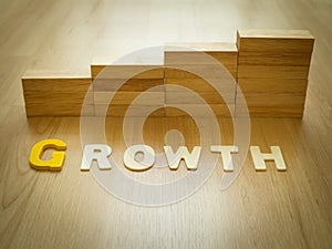 Growth word on wooden floor with wood block stacking as step stair in background. Business concept for growth success process.