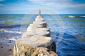 Groynes jut out into the Baltic Sea. Wooden trunks to protect the coast. Landscape