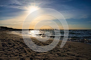 Groynes jut into the sea at sunset. The sun shines on the Baltic Sea. Landscape