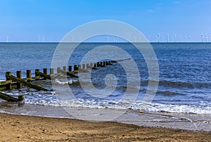 Groynes stretch out and submerging into the sea off Skegness beach, UK