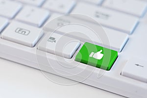 Grren key with Thumb up icon on white laptop keyboard. Social media concept