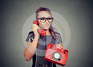 Grumpy displeased young woman having unpleasant phone conversation