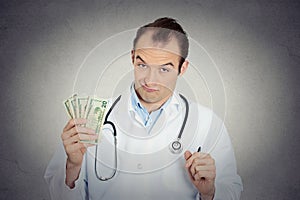 Grumpy greedy miserly health care professional holding money