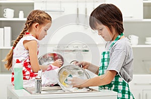 Grumpy kids doing home chores - washing dishes