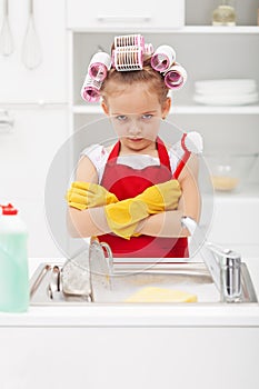 Grumpy little girl washing dishes photo