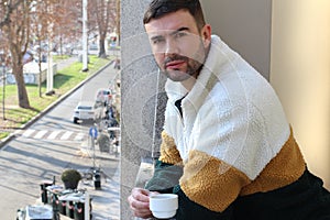 Grumpy looking man drinking his morning coffee