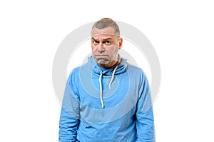 Grumpy man in blue sweater near white wall photo