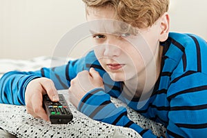 Grumpy petulant teenage boy watching television photo
