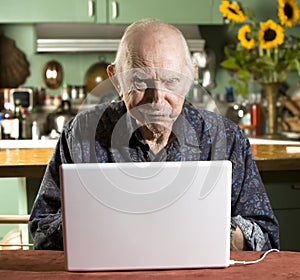 Grumpy Senior Man with a Laptop Computer