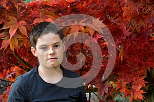 Grumpy teenage boy in autumnal nature