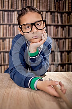 Grumpy young boy in library