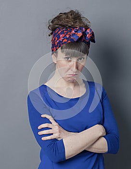 Grumpy young woman with fashionable hairstyle sulking, looking disappointed