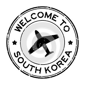 Grunge black welcome to South Korea word with airplane icon round rubber stamp on white background